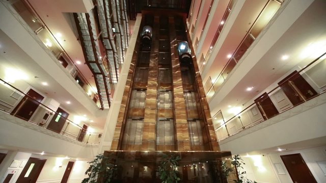 Wide view foors with railings and elevators in modern hotel