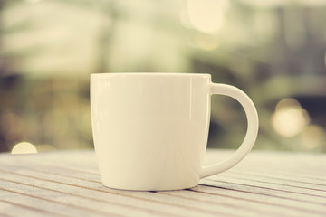 Coffee cup on wood table with blur background - vintage tone