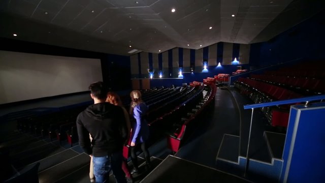 Four young people entered the dark hall cinema theater