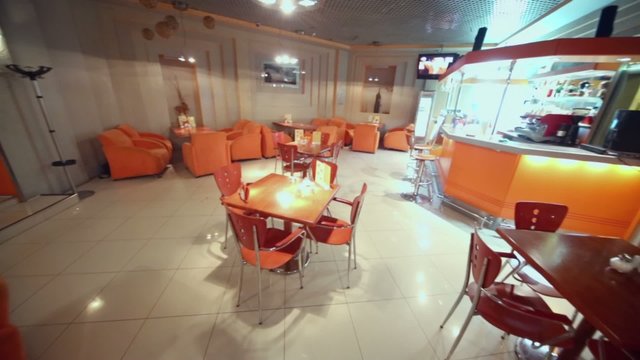 Chairs and tables in empty cafe-bar in orange tones
