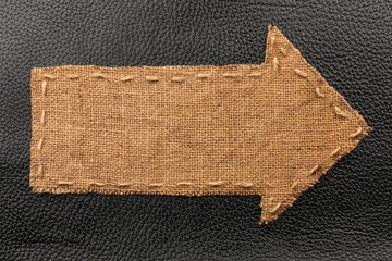 Arrow of burlap, lies on a background of leather