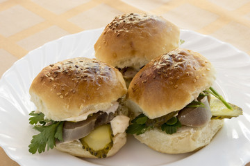 Three sandwich with beef tongue and pickles.