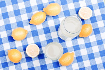 lemon juice and typical yellow sliced lemon on a green chalkboar