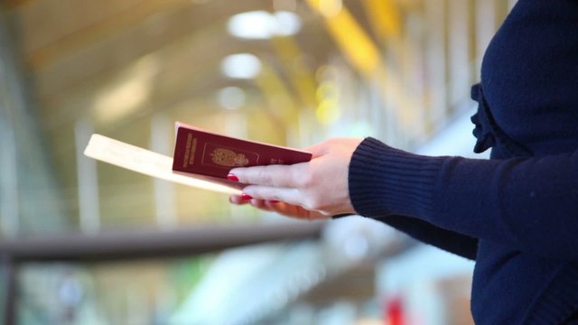 Russian girl looks at her passport and airline ticket