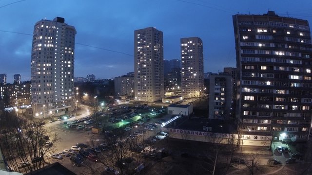Evening panorama of street with parking lot and traffic