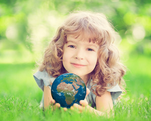 Fototapeta premium Child holding Earth planet in hands
