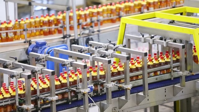 Filled and covered plastic bottles moving on conveyer line