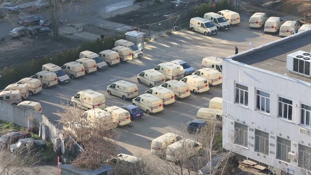 Parking lot of the beige cars at sunny day, view from the top