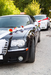 Fototapeta premium Luxury wedding black and white cars decorated with flowers
