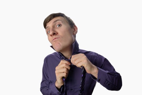 Young man who tries to tie one tie on white background