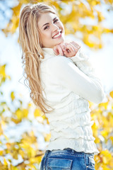 Portrait of beautiful young woman walking outdoors in autumn 