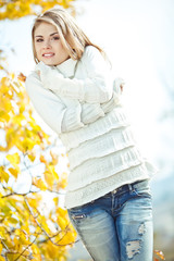 Portrait of beautiful young woman walking outdoors in autumn 