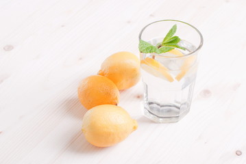 water with lemon and mint in a glass on the table top viewew