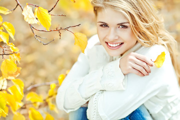 Portrait of beautiful young woman walking outdoors in autumn 