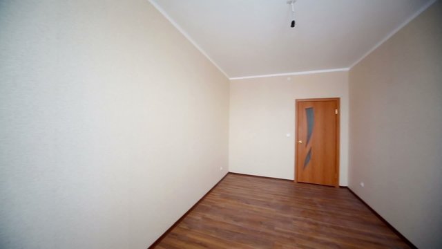 Overview of empty room with bare walls in new building.