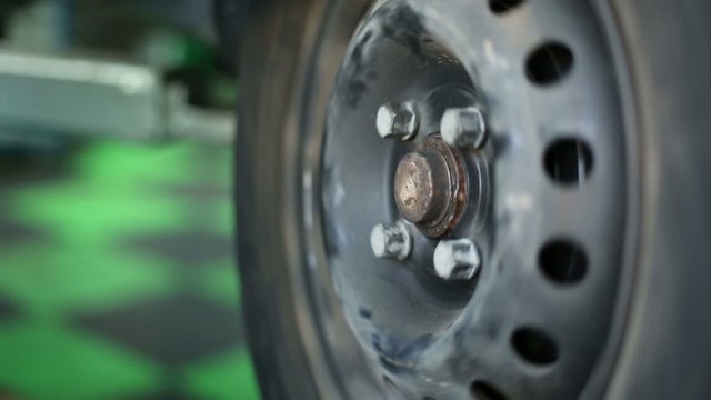 Male hands mount safety cap and wheel cover at service station