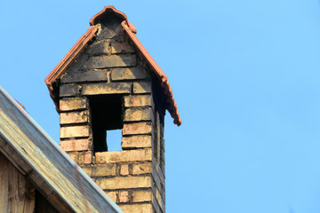 Fototapeta na wymiar chimney with roof against blue sky, copy space