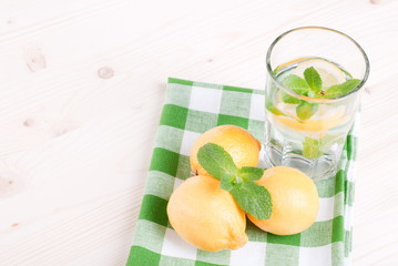 water with lemon and mint in a glass on the table top viewew