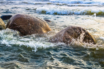 Fototapeta premium Waves crashing against stones