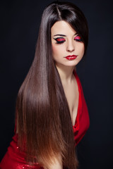 Beautiful woman with long brown straight hairs and red dress