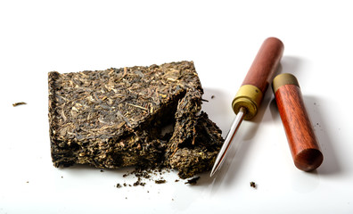 black pu-erh chinese tea with special knife on a white © Mivr