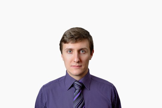 The young man in a violet shirt and a tie on white background