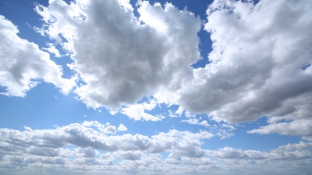 Clouds fly on blue sky in sunny weather, time lapse
