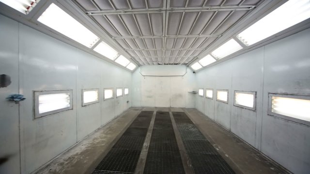Inside paint-spraying booth with metal walls for cars