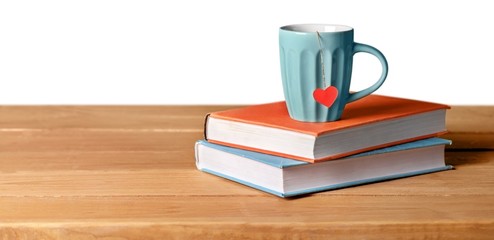 You. blue cup with red heart on green and orange books on grunge
