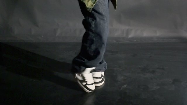 Hip-hop dancer dances in photo studio, only legs are visible