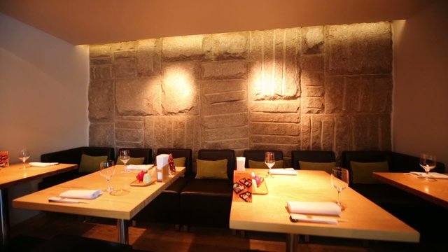 Stone wall and tables in cozy cafe with modern interior
