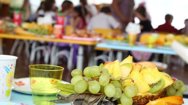 composition of grapes, pineapple, apple and orange on children