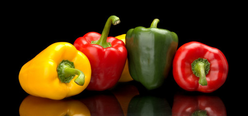 Red,green,yellow bell peppers isolated on black