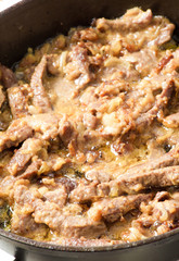 meat languor on a frying pan with sour cream