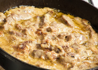 meat languor on a frying pan with sour cream