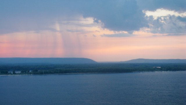 Evening view: soft raining above a wide river, timelapse