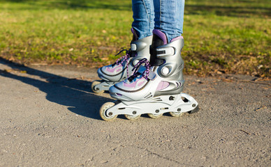 Fototapeta na wymiar roller skates on beautiful girl's feet in park