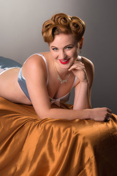 Fifties styled beautiful redheaded woman in satin lingerie