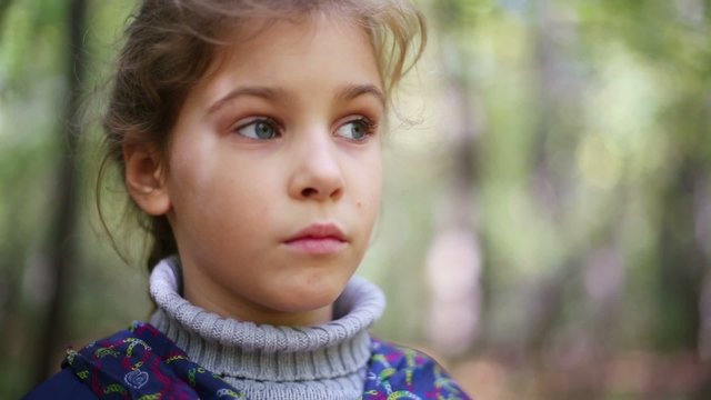 Face of little cute girl in knitted sweater outdoor
