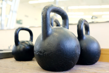 Naklejka na ściany i meble Large black kettlebells in weights room at the gym