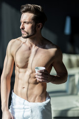 Fototapeta na wymiar Handsome, muscular, young man drinking his morning coffee