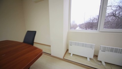 Small conference room with a wooden table, black chairs - Powered by Adobe