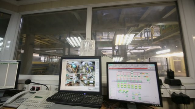 Man works in room of control devices in workshop