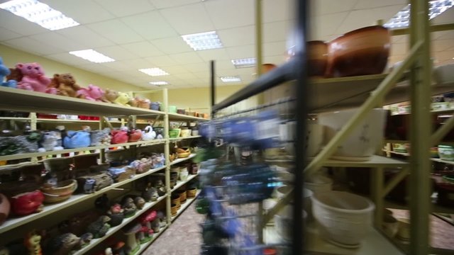 Warehouse with long shelves full of varicolored flowerpot