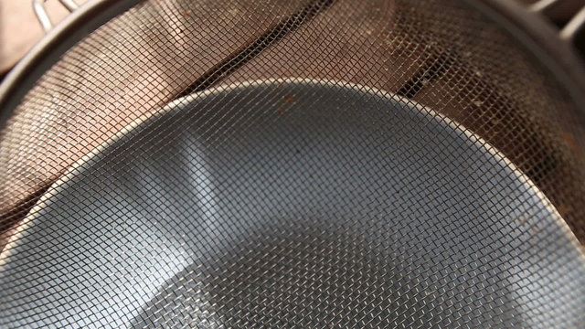 closeup of metal bolter for sifting flour on wooden table	