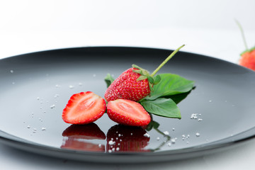 Fresh of half strawberry on black dish and reflex