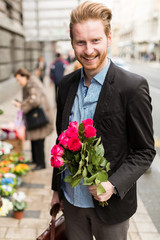 Businessman holding flowers and smiling