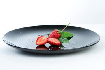 Fresh of half strawberry on black dish and reflex