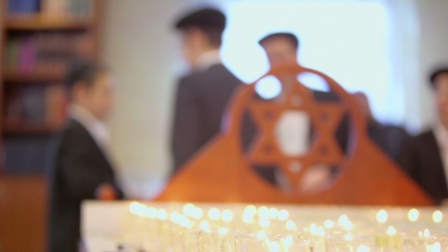 jewish boys near funeral candles and wooden merkaba in synagogue