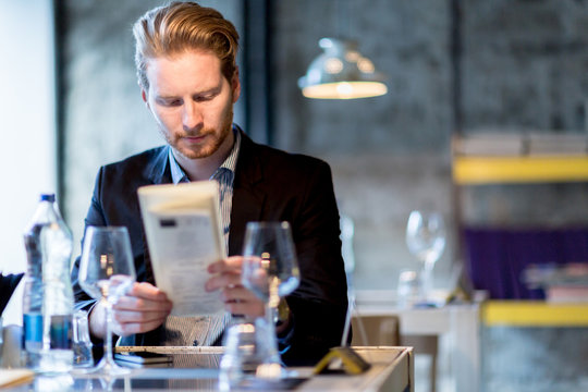 Businessman holding the menu in a restaurant
